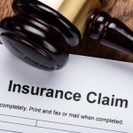 an insurance claim form next to a gavel