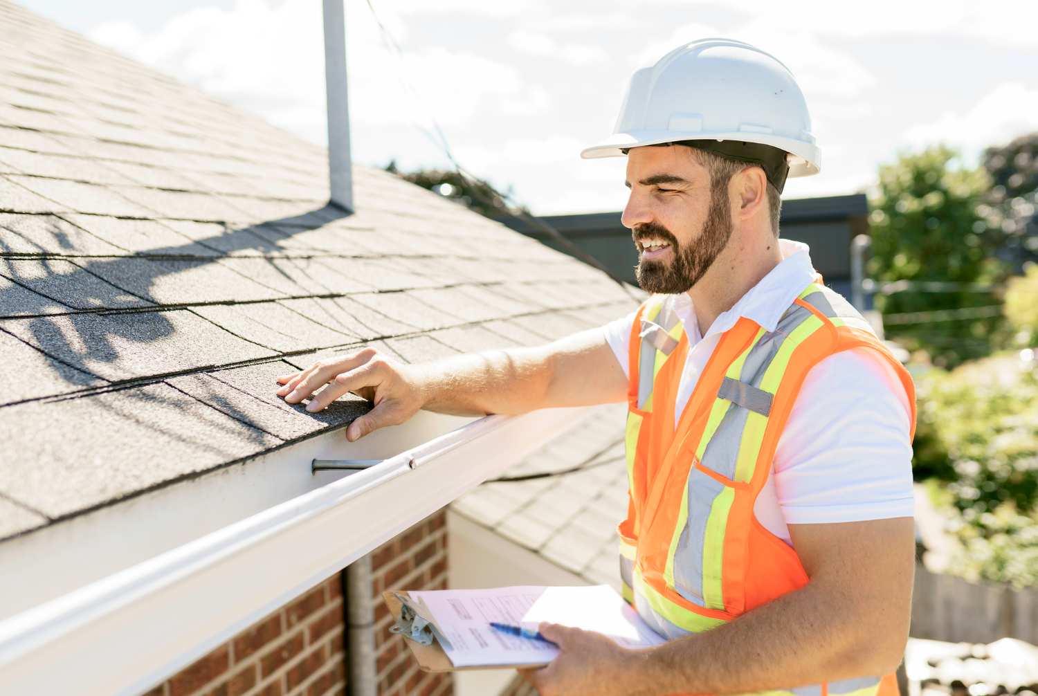 man in hi-vis vest inspecting roof